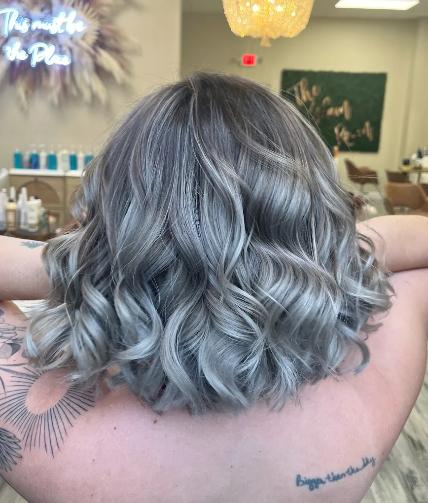 Back view of a silver-blonde curled bob styled at The Glam Room