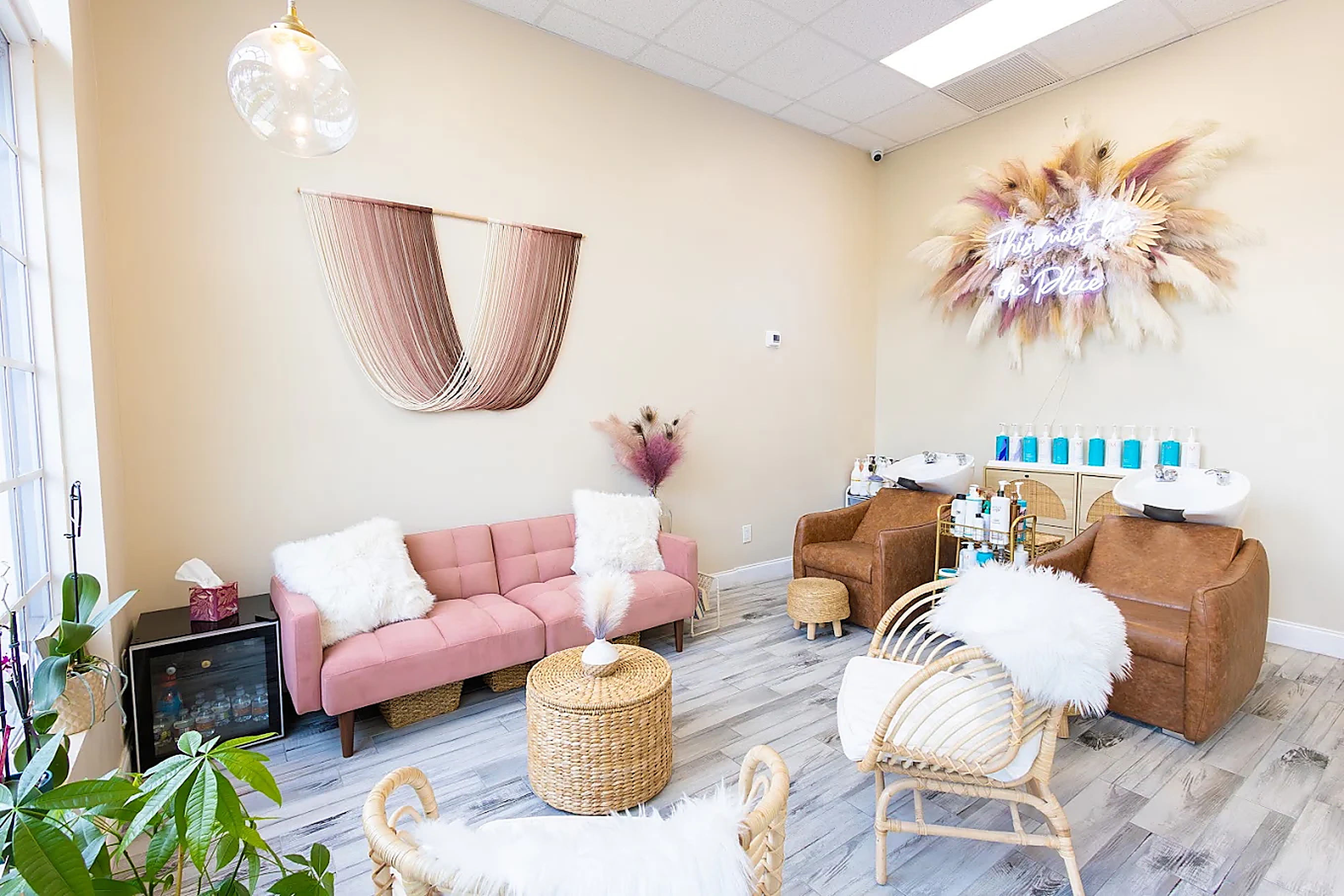 The warm, boho-chic waiting area inside The Glam Room in Wellington, Florida
