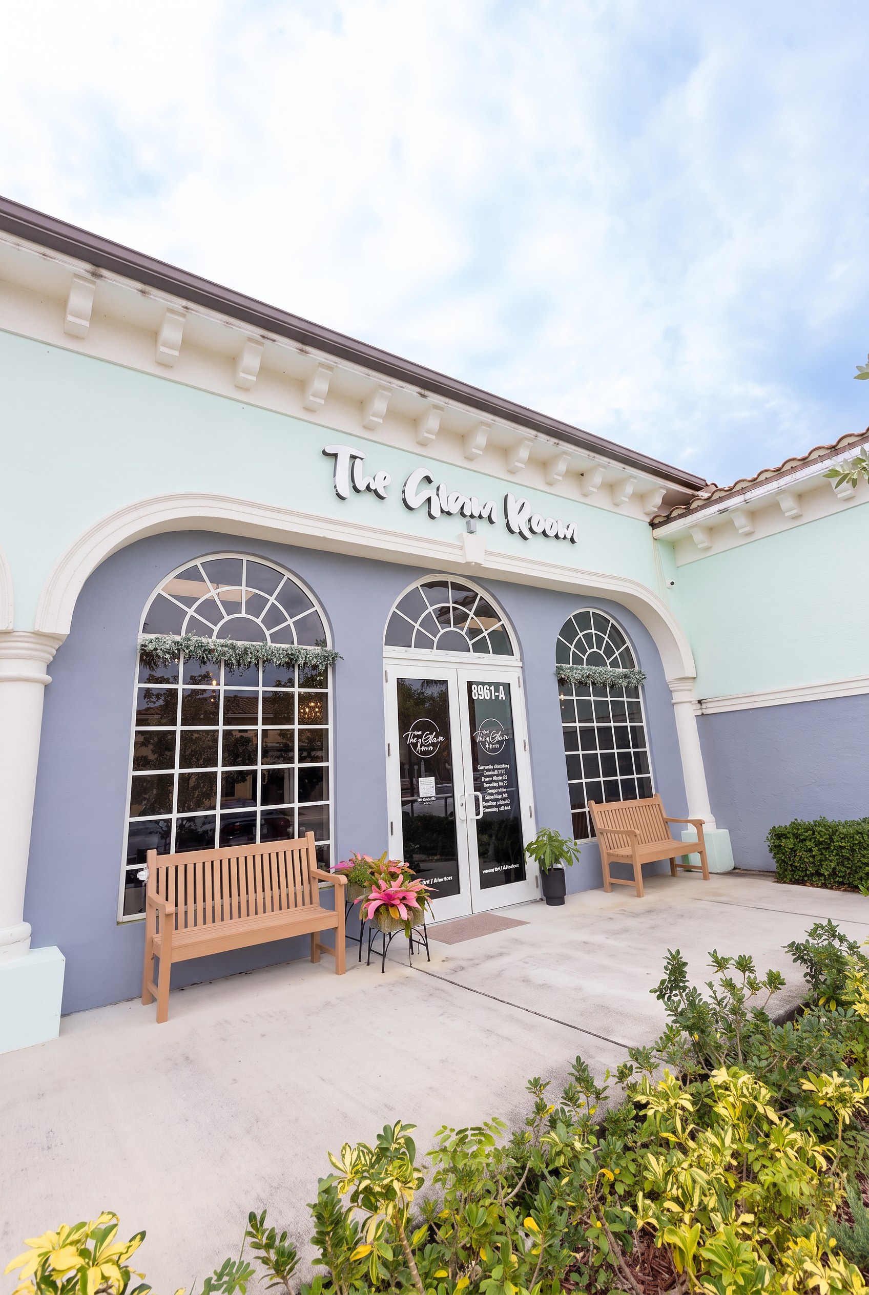 The Glam Room storefront with its blue arched facade and wooden benches